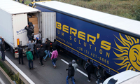 Hình ảnh người nhập cư nhảy lên xe tải đang chạy để vào Anh