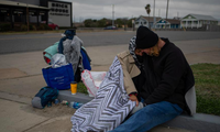 Một cặp vợ chồng người Texas ngồi sát bên nhau bên lề đường. Họ cho biết họ bị mất nhà sau khi mất việc năm 2020 vì đại dịch COVID-19. (Ảnh: Reuters)