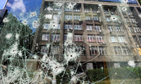 Cửa sổ một cửa hàng bị thủng lỗ chỗ ở Kharkiv ngày 23/5. (Ảnh: Reuters)