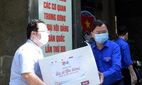 Anh Nguyễn Anh Tuấn và các đoàn viên thanh niên chuyển các thùng quà lên xe đến với các vùng dịch. Ảnh: Xuân Tùng