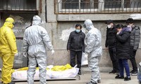 Công nhân nhà tang lễ thu dọn xác của một người bị nghi là đã chết vì dịch coronavirus từ một tòa chug cư ở Vũ Hán, tỉnh Hồ Bắc, Trung Quốc ngày 1/2 (AP)