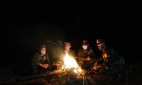 Đêm lạnh và sương giá, đội hình biên phòng ở chốt 1322 đốt lửa sưởi ấm, ngay phía sau họ là đường biên Việt - Trung. Ảnh: Nguyễn Minh