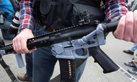 Một người đem khẩu "súng ma" được làm bằng các bộ phận in 3D tham gia biểu tình (Ảnh: Reuters)