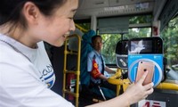 Một hành khách dùng ứng dụng Alipay để thanh toán trên chuyến xe buýt ở tỉnh Chiết Giang ngày 16/8/2016. Ảnh: Xinhua