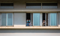 Các bệnh nhân nhìn ra từ cửa sổ bệnh viện Kim Ngân Đàm ở Vũ Hán. Ảnh: EPA-EFE