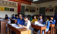 “Giáo viên” áo xanh nhiệt tình chỉ dẫn cho các em học sinh kiến thức môn tiếng Anh. Ảnh: Giang Thanh
