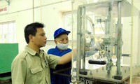 Kỹ sư Nguyễn Tiến Hưng (trái) kiểm tra thiết bị sản xuất sản phẩm quốc phòng tại Xí nghiệp II . Ảnh: PV