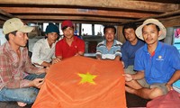 Ngư dân Nguyễn Văn Tâm (ngoài cùng bên phải) đã nhảy xuống biển vớt lá cờ Tổ quốc Ảnh: Văn Chương