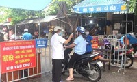Đo nhiệt độ người dân trước khi họ vào chợ tại Hải DươngNguồn: QĐND