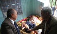 Bộ trưởng Nguyễn Quốc Triệu (trái) bên giường bệnh thi sĩ Hữu Loan