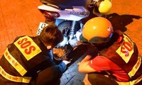 Thành viên đội SOS BMT sửa xe máy cho người đi đường Ảnh: H.T