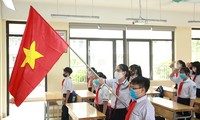 Học sinh đeo khẩu trang, chào cờ tại lớp học trong ngày đầu trở lại trường 