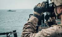 Một lính thủy đánh bộ Mỹ quan sát một tàu Iran đi qua eo biển Hormuz. Ảnh: Reuters 