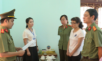 Bị can Nguyễn Thị Hồng Nga (áo trắng bên phải) nghe tống đạt quyết định khởi tố.