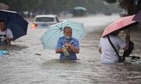 Nước ngập ngang thắt lưng người đi đường ở Trịnh Châu (Hà Nam, Trung Quốc). Ảnh: Reuters