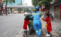 Bức ảnh 2 bé gái diện áo dài, phụ mẹ làm lao công đẩy xe rác trên phố gây xúc động