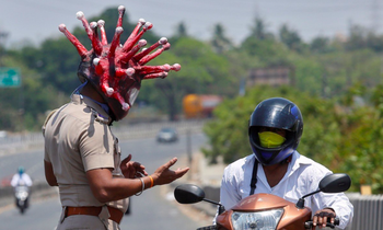 Một cảnh sát Ấn Độ đội mũ bảo hiểm hình virus corona. (Ảnh: Reuters)