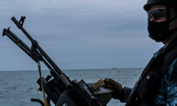 Một lính Nga tuần tra trên biển Azov ngày 19/4, cách đó không xa là một tàu của Nga. (ảnh: NYT)
