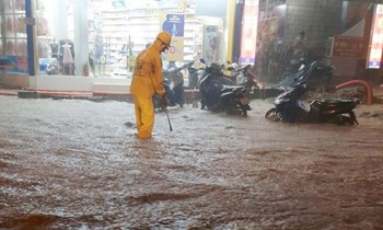 Mưa ngập cả bánh sau xe máy dựng trên vỉa hè phố Vũ Trọng Phụng