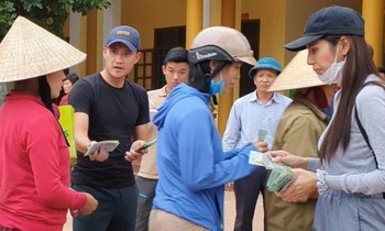 Ca sĩ Thủy Tiên trao tiền hỗ trợ cho người dân bị ảnh hưởng bởi lũ lụt.