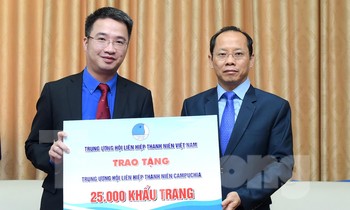 Mr. Nguyen Tuong Lam presented a signboard of 25,000 masks to Mr. Chay Navuth. Photo: Xuan Tung
