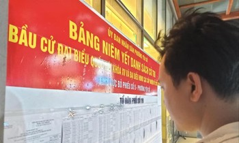 Người dân theo dõi danh sách cử tri được niêm yết tại phường Yên Sở, quận Hoàng Mai, Hà Nội. Ảnh: LD