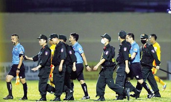 Lực lượng cảnh sát cơ động áp tải tổ trọng tài rời sân ở trận TPHCM và Thanh Hoá ngày 12/4 ảnh: CTV