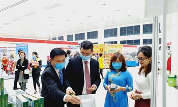 Dinh Nguyen Hoang Thu (far right) introduces guests to spirulina products at a trade promotion event.  Photo: NVCC 