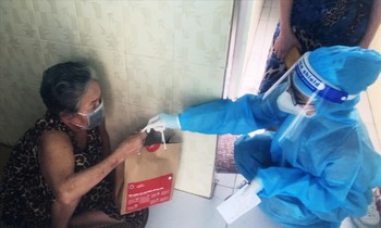 Nhân viên y tế phát túi thuốc cho F0 thực hiện cách ly, điều trị tại nhà