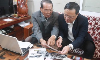 Ông Lê Ðình Rê (trái) chia sẻ những tư liệu quý với Chủ tịch UBND huyện Hoàng Sa Võ Ngọc Ðồng. Ảnh: Nguyễn Thành