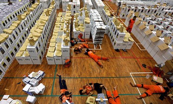 Các nhân viên nằm nghỉ tại chỗ trong giờ giải lao trong khi chuẩn bị tài liệu bầu cử. Ảnh: Reuters