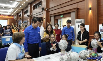 Anh Nguyễn Ngọc Lương, Bí thư T.Ư Đoàn, Chủ tịch Hội đồng Đội T.Ư (thứ hai, từ trái qua) xem học sinh Hà Nội làm các sản phẩm tái chế trong khuôn khổ chương trình trao giải cuộc thi ảnh "Việc tốt vì trẻ em". ẢNH: BẢO ANH