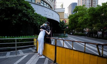 Hai cô gái ôm nhau qua hàng rào vây một khu dân cư ở Thượng Hải ngày 16/5. (Ảnh: Reuters)