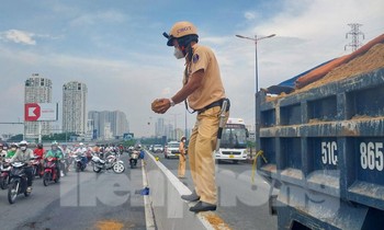 CSGT dùng tay không hốt cát lấp vệt dầu nhớt giữa cầu được dân 'thả tim'