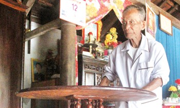 Nghệ nhân Đinh Thạch bên chiếc bàn xoay do cụ chế tác. Ảnh: H. Văn.