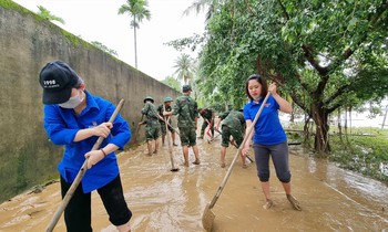 Các tình nguyện viên lội bùn giúp dân dọn đường sá, nhà cửa sau mưa lũ. Ảnh: NVCC 