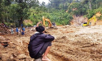 Phóng viên Nguyễn Thành (áo trắng) cùng đồng nghiệp tìm sóng lạc giữa núi rừng Trà My để gửi hình ảnh sớm nhất về tòa soạn. Ảnh: Cảnh Huệ