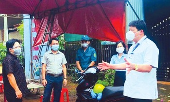 Chủ tịch huyện Nguyễn Văn Hà (bìa phải) đang trao đổi công việc tại chốt kiểm dịch