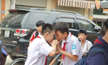 Hai học sinh tại cổng trường Mễ Trì (Hà Nội) vô tư uống chung một cốc nước ngọt