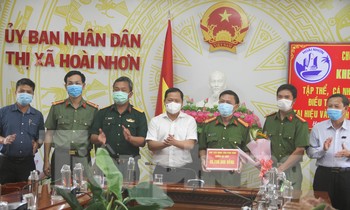 Chủ tịch UBND tỉnh Bình Định Nguyễn Phi Long khen thưởng cho tập thể, cá nhân có thành tích xuất sắc điều tra, phá vụ án trộm cắp tài sản tại hiệu vàng Anh Trung. Ảnh: Trương Định