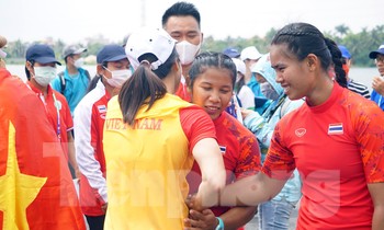 Nữ VĐV Canoeing Việt Nam bắt tay, trò chuyện với đối thủ Thái Lan sau cuộc đua gay cấn trên sông Giá, Hải Phòng.