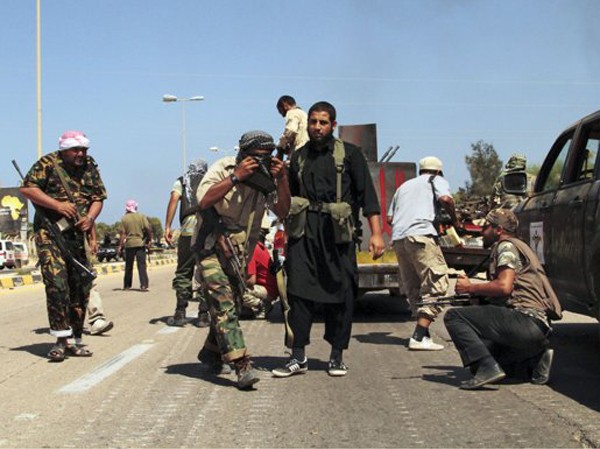 Quân ông Gaddafi từ Algeria về nước Lính NTC tránh trọng pháo, rocket và tên lửa của quân Gadhafi hôm 24-9 ở Sirte. Ảnh: Gaia Anderson