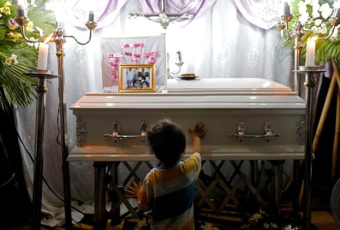 Phẫn nộ cảnh sát Philippines bắn bé gái 3 tuổi bị bố dùng làm 'lá chắn sống' Anh trai cô bé Myka Ulpina đứng trước thi thể em gái. (Ảnh: Reuters)
