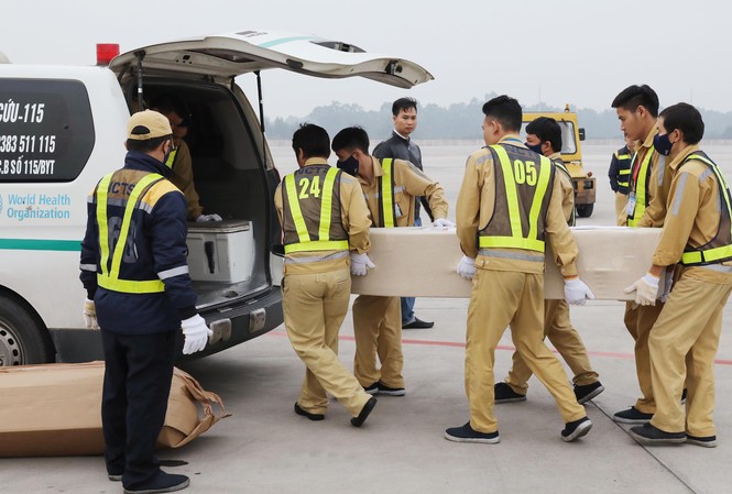 Vụ 39 người tử vong trên xe tải ở Anh: 23 thi hài, tro cốt còn lại về Việt Nam Vận chuyển các thi hài và tro cốt ra xe để đưa về địa phương. (Ảnh: TTXVN)
