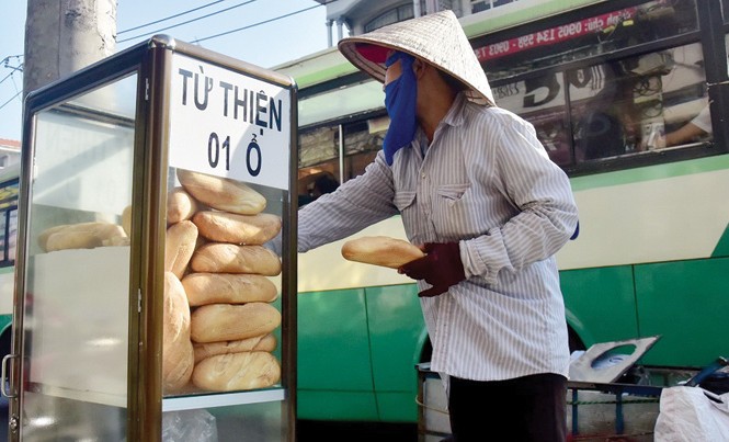 Miền đất cảm hóa con người Một người mua ve chai đang lấy bánh mì từ thiện.