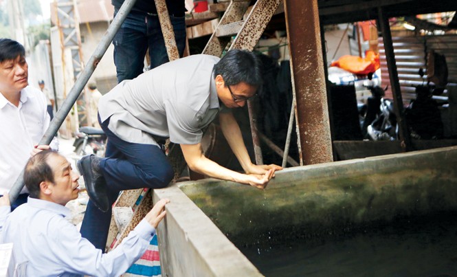 Phó Thủ tướng sốt ruột vì dịch sốt xuất huyết bùng phát giữa thủ đô Phó Thủ tướng Vũ Đức Đam đích thân vục nước kiểm tra bọ gậy, loăng quăng trong bể nước tại một công trường xây dựng ở phường Láng Thượng, thuộc quận Đống Đa, Hà Nội, chiều 28/7. Ảnh: Như Ý.