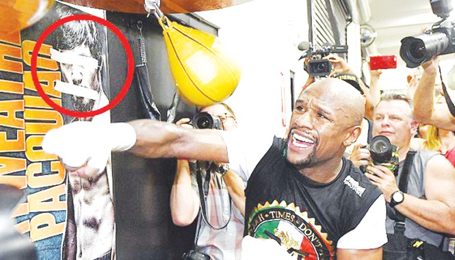 Trận đấu 300 triệu USD: Cú áp chót của Mayweather Mayweather tập luyện bên tấm poster có hình đối thủ Pacquiao của anh bị bịt mắt, bịt miệng bằng băng keo. Ảnh: Getty Images