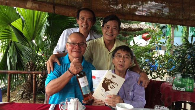 Nhà văn đạp xe xuyên Việt Nhà thơ Thanh Thảo (ngồi, phải) tặng sách nhà văn Phạm Ngọc Tiến
