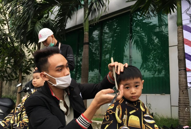 Ấm lòng 'cắt tóc miễn phí' cho người lao động nghèo Anh Gia Bảo chăm chú làm đẹp cho vị khách nhỏ. Ảnh: Đ.T