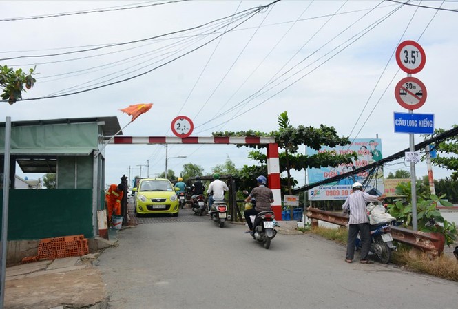Truy trách nhiệm dự án 'rùa' ở TPHCM Cầu Long Kiểng mới chưa xong nên người dân hàng ngày phải lưu thông qua cây cầu cũ bằng sắt từng bị sập một lần do xe quá tải.